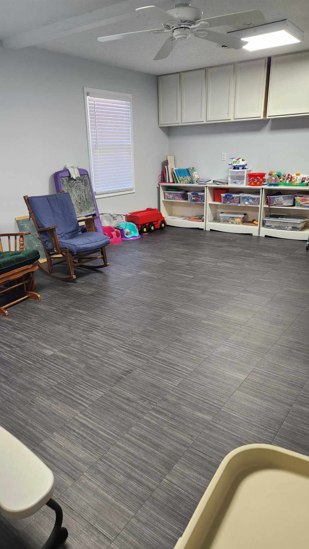 The same daycare playroom with a clear floor and the toy shelves put back in order after service